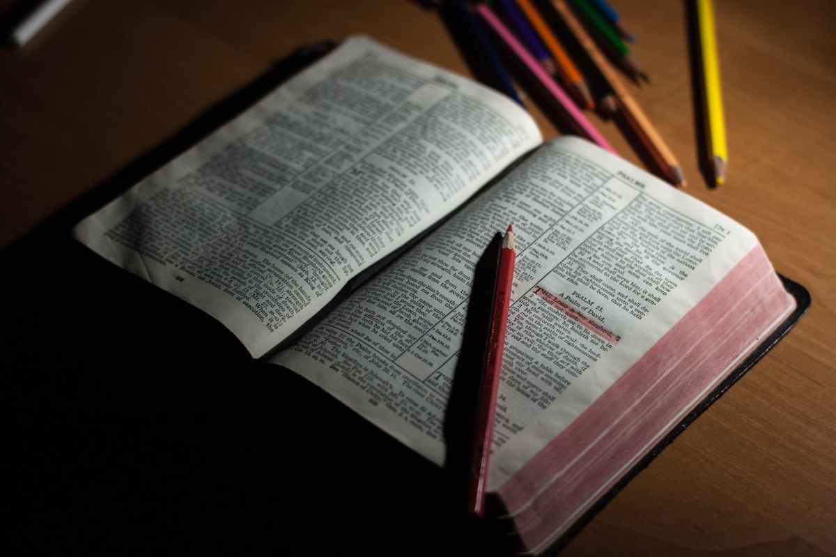pink pencil on open bible page and pink